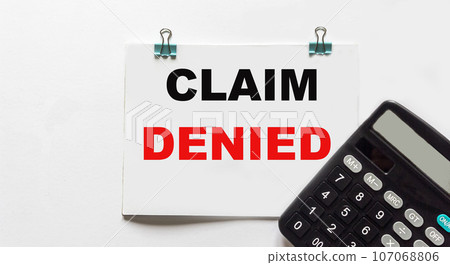 The word CLAIM REJECTED is written on a sticker that lies on the calculator  107068806