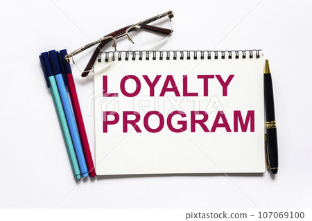 Loyalty program card with white background and a pen, glasses and markers nearby. Loyalty program card with white background and a pen, glasses and markers nearby. 107069100