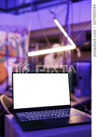 Laptop with white blank screen mock up for ransomware in abandoned warehouse. Portable computer with empty display for malicious software code in hackers hideout place at night 107069394