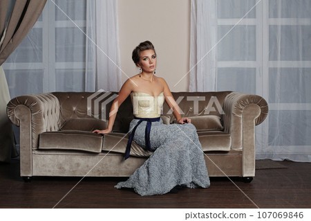 Beautiful woman fashion model sitting in luxurious interior 107069846