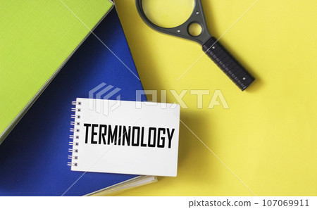 Notepad with text TERMINOLOGY on yellow background with blue folders 107069911