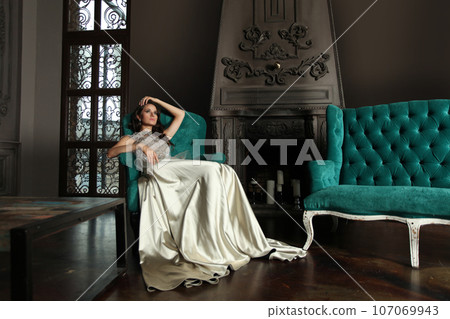 Gorgeous nice woman fashion model sitting in luxurious interior 107069943