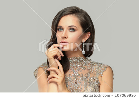 Beautiful glamorous young woman with makeup and diamond earring, fashion beauty portrait Beautiful glamorous young woman with makeup and diamond earring, fashion beauty portrait 107069950