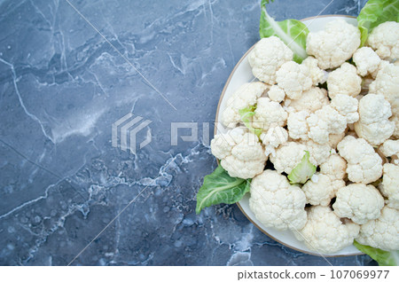 Cauliflower inflorescences  close-up on a plate, top view, space for text 107069977