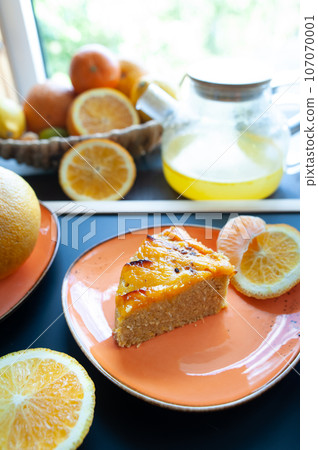 Orange cake or pie. Cozy home baking concept. Still life with delicious pie, tea surrounded by citrus fruits Orange cake or pie. Cozy home baking concept. Still life with delicious pie, tea surrounded by citrus fruits 107070001