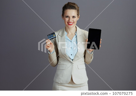 smiling modern employee with digital tablet and credit card smiling modern employee with digital tablet and credit card 107070275