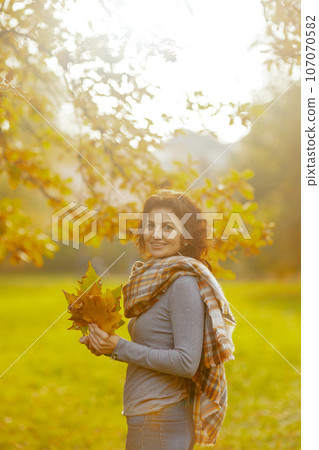 Portrait of happy stylish 40 years old woman in park Portrait of happy stylish 40 years old woman in park 107070582