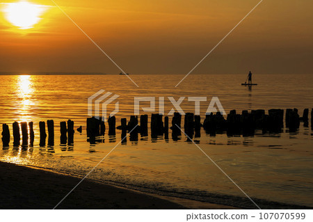 sunset on the sea, a ship in the distance against the background of the sun 107070599