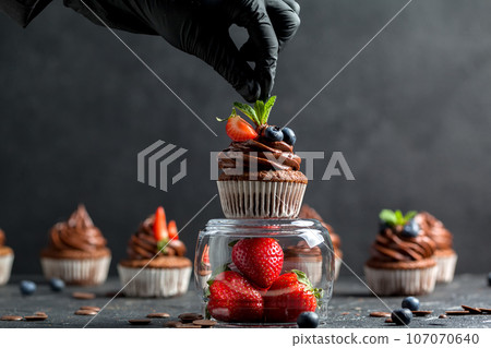 Chocolate cupcakes. Freshly baked muffins with fresh berries Chocolate cupcakes. Freshly baked muffins with fresh berries 107070640