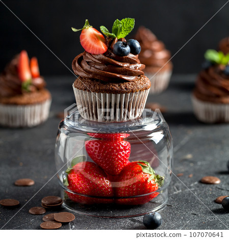 Chocolate cupcakes. Freshly baked muffins with fresh berries Chocolate cupcakes. Freshly baked muffins with fresh berries 107070641