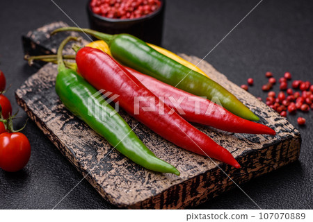 Hot chili peppers of three different colors red, green and yellow 107070889