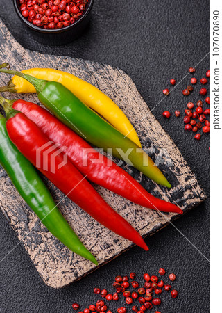 Hot chili peppers of three different colors red, green and yellow 107070890