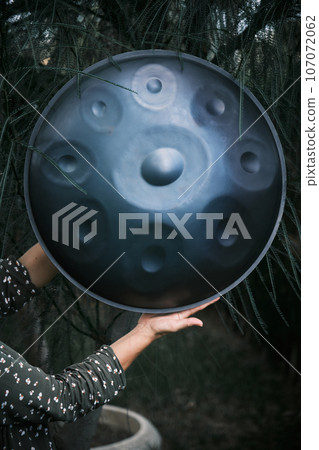 hang handpan in a woman hands hang handpan in a woman hands 107072062