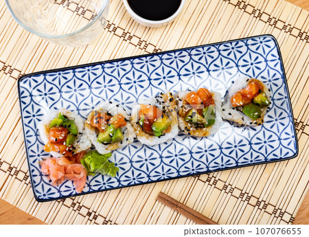 Saketaki roll served with soya sauce and wasabi in a plate 107076655