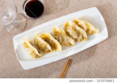 Japanese boiled gyoza dumplings served with tare sauce 107076661