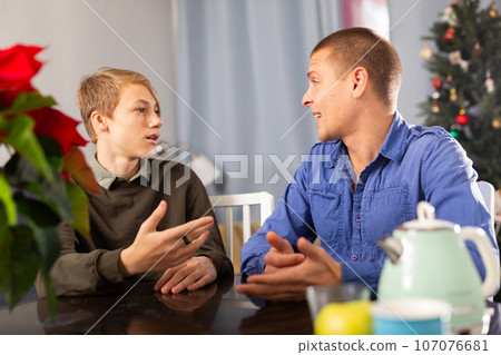 Father sitting with son during Christmas evening 107076681