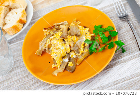 Just cooked scrambled eggs with asparagus and mushrooms served on table and ready-to-eat. 107076728