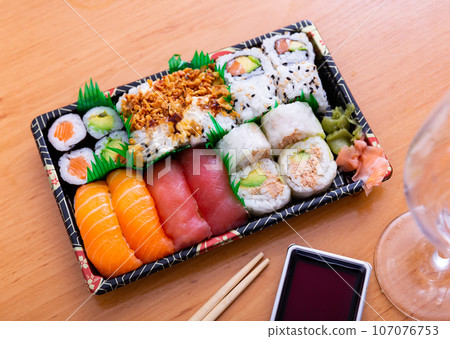 Set of nigiri and sushi rolls with salmon, tuna, avocado, fried onions Set of nigiri and sushi rolls with salmon, tuna, avocado, fried onions 107076753