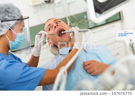 Woman doctor treats patient teeth using boron machine in clinic Woman doctor treats patient teeth using boron machine in clinic 107076770