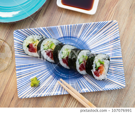 Set of japanese rolls futomaki with soy and chili sauces close up 107076991