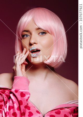 Glamorous portrait of a young woman with pink hair and glitter on her lips Glamorous portrait of a young woman with pink hair and glitter on her lips 107077921
