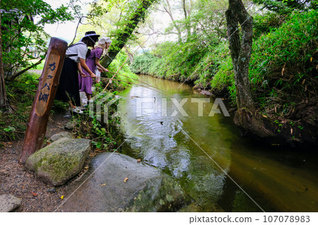A woman fishing for a raincoat A woman fishing for a raincoat 107078983