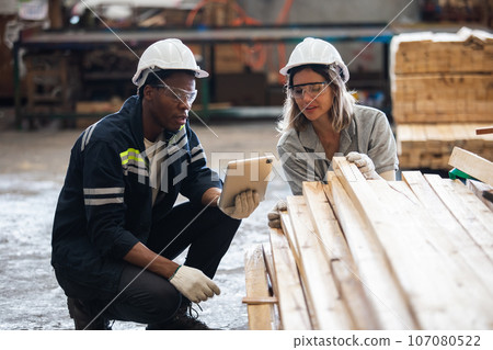 Team engineer carpenter wearing safety uniform and hard hat working using tablet checking quality Team engineer carpenter wearing safety uniform and hard hat working using tablet checking quality 107080522