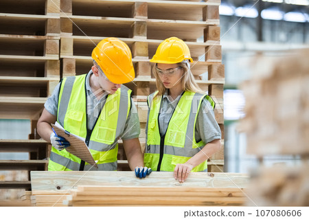 Team engineer carpenter wearing safety uniform and hard hat working holding clipboard checking. Team engineer carpenter wearing safety uniform and hard hat working holding clipboard checking. 107080606