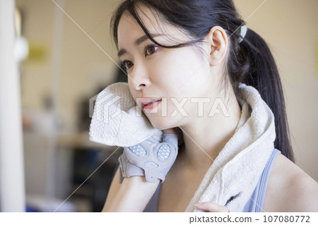 Young woman wiping sweat at the gym 107080772