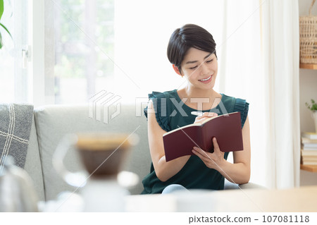 A woman looking at a notebook in the living room A woman looking at a notebook in the living room 107081118