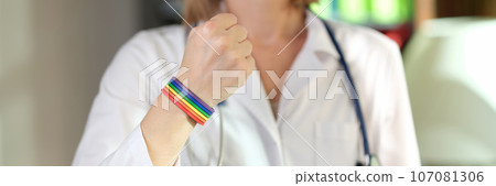 Female doctor shows her fist and rainbow bracelet on her hand. Female doctor shows her fist and rainbow bracelet on her hand. 107081306