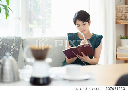 A woman looking at a notebook in the living room 107081320
