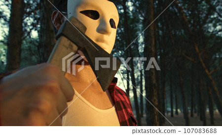 Masked Assassin Man With Axe Walk In The Forest Of Mountains 107083688