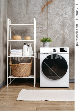 Washing machine in a gray modern laundry room 107084291
