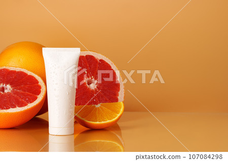 Cosmetic container on background of cut citrus fruit 107084298