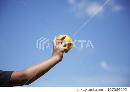 Playing catch with elementary school students against the blue sky - exercise image 107084395