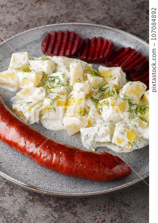 Swedish Isterband pork sausage with creamed potatoes with dill and boiled beets close-up on a plate. vertical 107084892