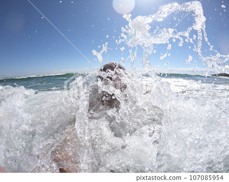 Windy ocean waves splashing on a guy Windy ocean waves splashing on a guy 107085954