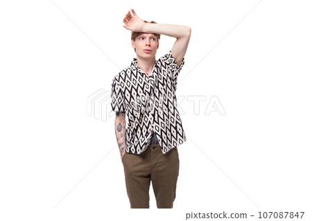 a young smart smart guy with red hair and a tattoo on his arms is dressed in a short-sleeved shirt a young smart smart guy with red hair and a tattoo on his arms is dressed in a short-sleeved shirt 107087847