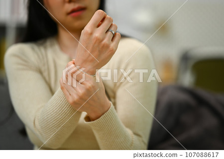 Young woman suffering from pain in hand or wrist, having osteoarthritis rheumatoid arthritis, health care problem 107088617