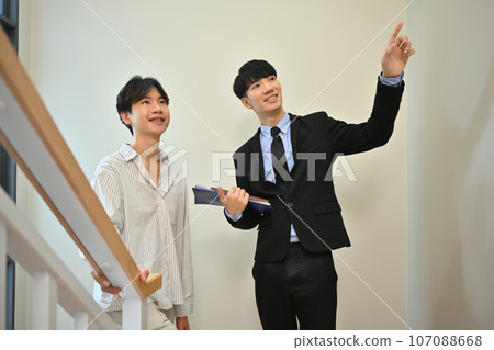 Male real estate agent showing new house to client. Real estate mortgage and property investment concept 107088668