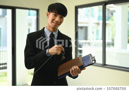 Professional male realtor or broker holding keys. Real estate service, mortgage and property investment concept Professional male realtor or broker holding keys. Real estate service, mortgage and property investment concept 107088708