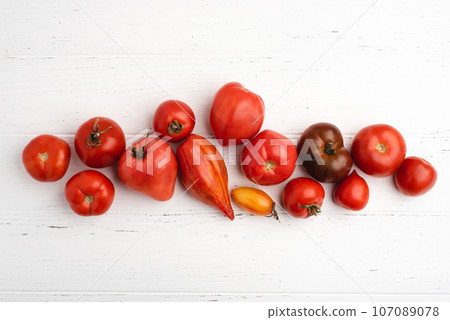 Fresh harvest of red tomatoes on a white wooden table. Fresh harvest of red tomatoes on a white wooden table. 107089078