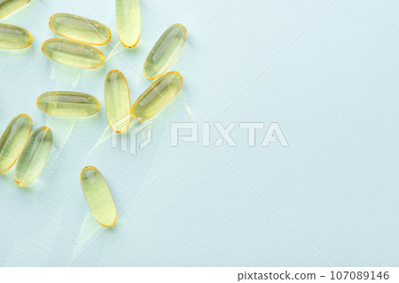 Omega 3 fish liver oil capsules on blue background. 107089146