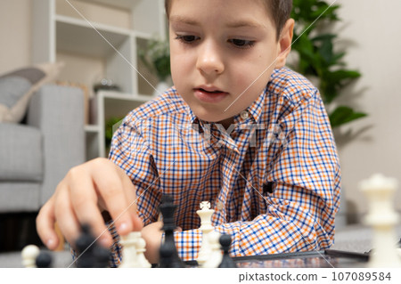 Little boy playing chess. Board games for children Little boy playing chess. Board games for children 107089584