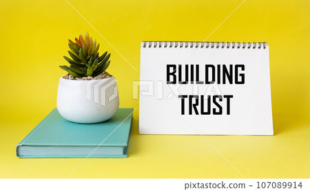 Confidence building text on notepad and yellow background with flower. Business concept 107089914