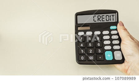Calculator with word CREDIT on display in female hand. Money, finance and business concept 107089989