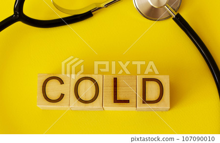 Stethoscope, wooden cubes with text on a yellow background Stethoscope, wooden cubes with text on a yellow background 107090010