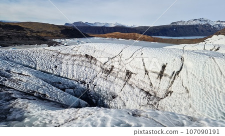 Vatnajokull ice fragments in frosty scenery, creating majestic glacier lagoon in northern region landscape. Spectacular icelandic scenery with big transparent icebergs with ice crevase. Vatnajokull ice fragments in frosty scenery, creating majestic glacier lagoon in northern region landscape. Spectacular icelandic scenery with big transparent icebergs with ice crevase. 107090191