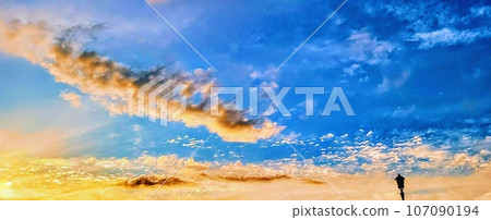 Clouds and street lights colored by the sunset Clouds and street lights colored by the sunset 107090194